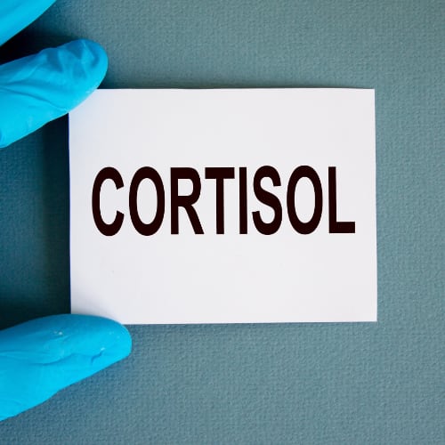 white sticky note held by a medical technician that says cortisol