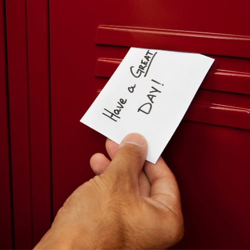 the words have a great day written on a note card and placed inside a school locker