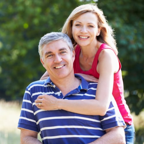 middle aged couple outdoors in loving pose