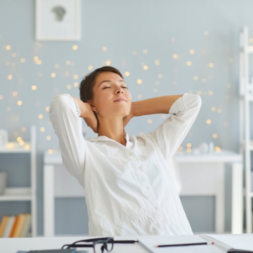 woman relaxing in her home office taking a break from her work