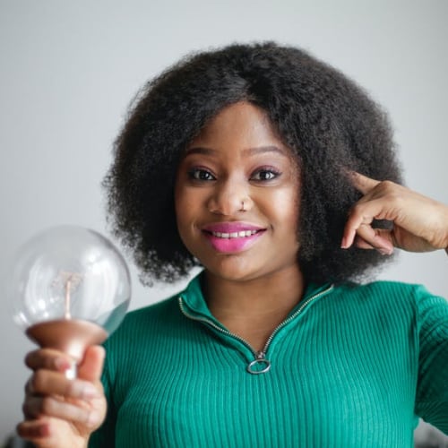 African American woman with idea holding a lightbulb