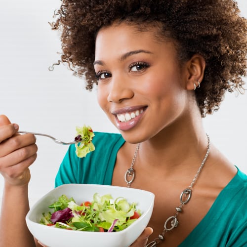 african american woman eating salad