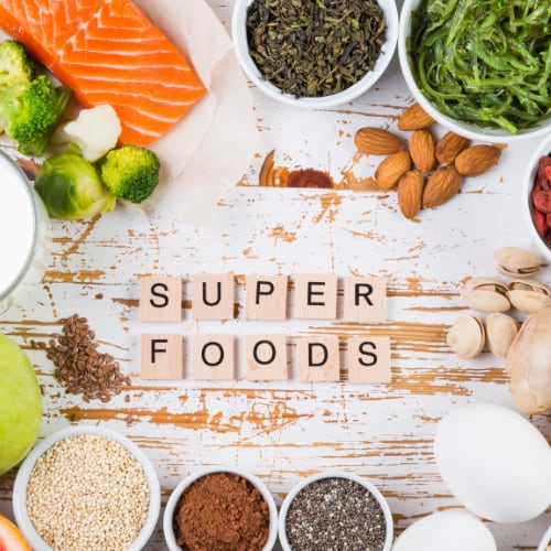 an assortment of superfoods including nuts, berries, vegetables, salmon