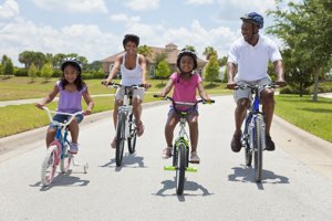 attractive young black family riding bicycles together