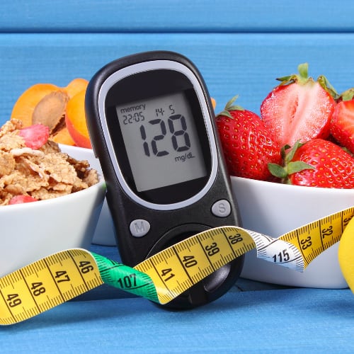 healthy foods and blood sugar monitor depicting a high blood sugar level
