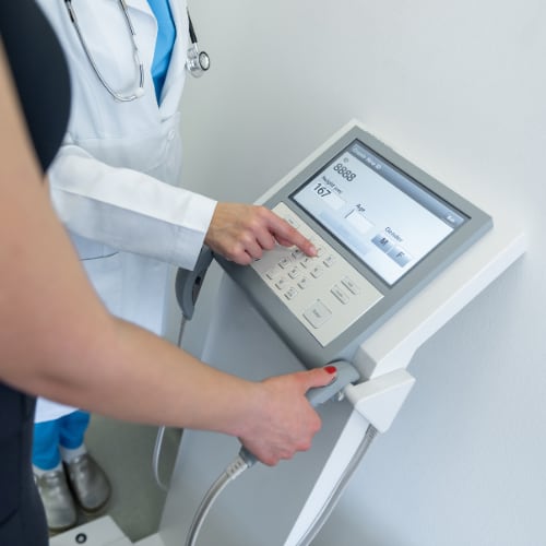 a woman having her body composition measured with a healthcare provider