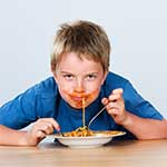 a boy without manners sits at the table with his sister