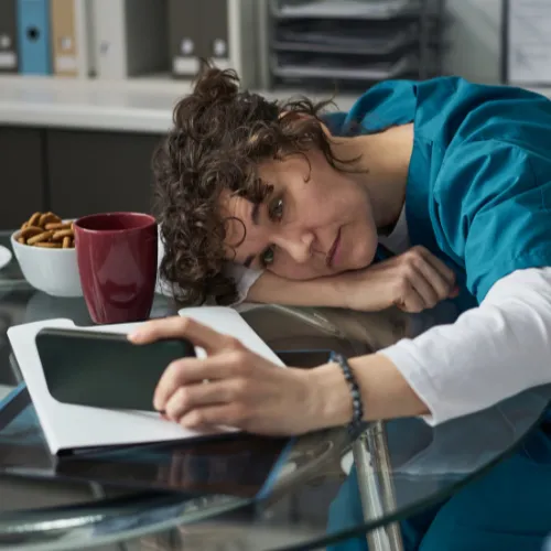 A person at a desk reaching for coffee and snacks during an afternoon energy slump.