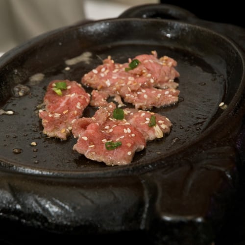 heavy black skillet on gas stove cooking beef