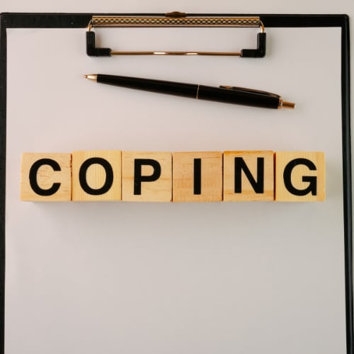 clipboard with the word coping depicting coping skills to manage stress