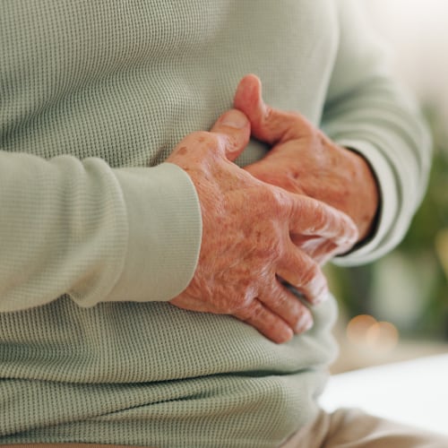 a man with his hands on his stomach indicating discomfort