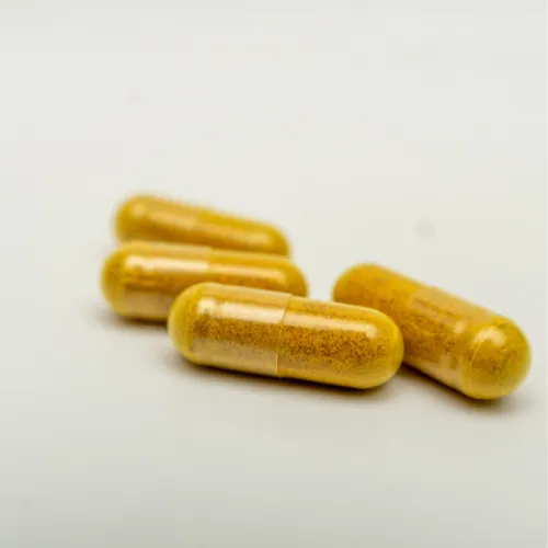 A plate of food with capsules placed beside it, showing digestive enzymes used alongside a meal.