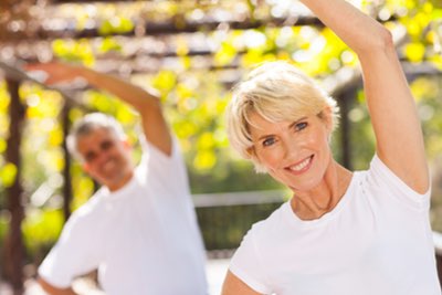 Senior caucasian couple exercising by doing stretches.