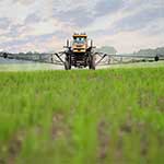 farmer sprays pesticides on crops