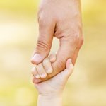 Father's hand reaching into a child's hand