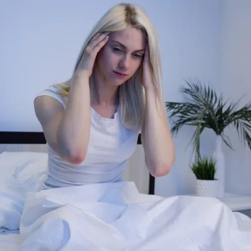 A tired person resting at home while still appearing mentally alert and unrested.
