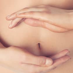 a woman's belly with hands depicting a colon cleanse