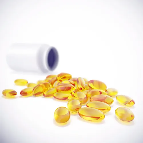 A bottle of fish oil softgels with capsules visible on a kitchen counter in a home setting.