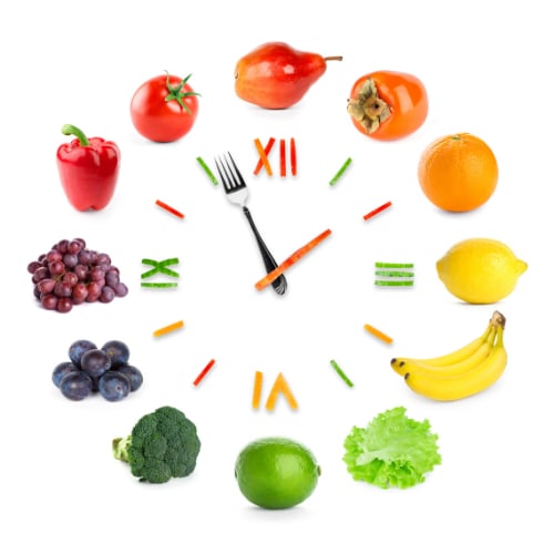 healthy fruits and vegetables arrayed around a clock