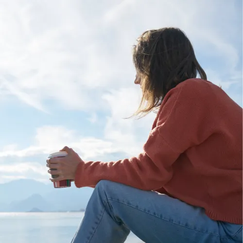 A person sitting quietly at a kitchen table in a reflective state, representing the connection between digestion and mental experience.