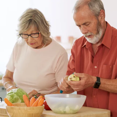 A person preparing a simple meal with fresh ingredients in a home kitchen, reflecting everyday digestive health.