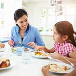 Happy young asian family eating a healthy meal together at table. 