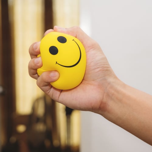 stress ball with a happy face depictcting a positive, constructive way to manage stress