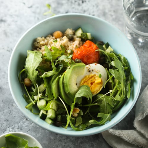 healthy quinoa bowl with arugula, egg, and avocado