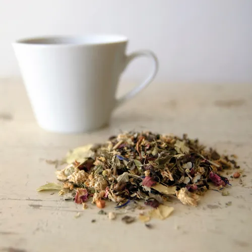 Herbal tea preparations and liquid herbal extracts arranged side by side on a table.