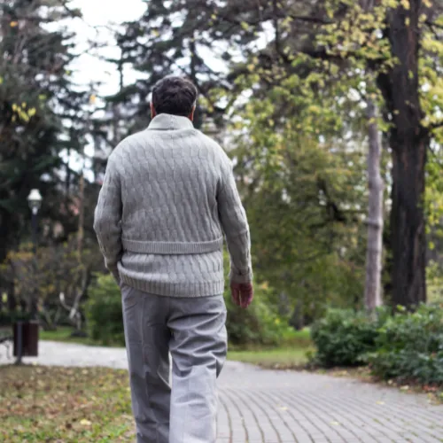 An adult walking calmly outdoors, reflecting gradual changes in recovery capacity and resilience over time.