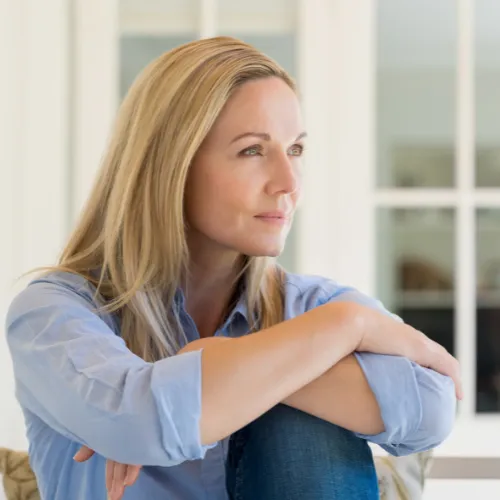 A person sitting quietly with a thoughtful expression after a demanding day, reflecting the cumulative effects of stress on emotional wellbeing.