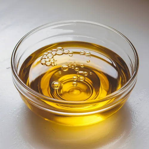 Liquid oil supplement in a glass container on a neutral surface.