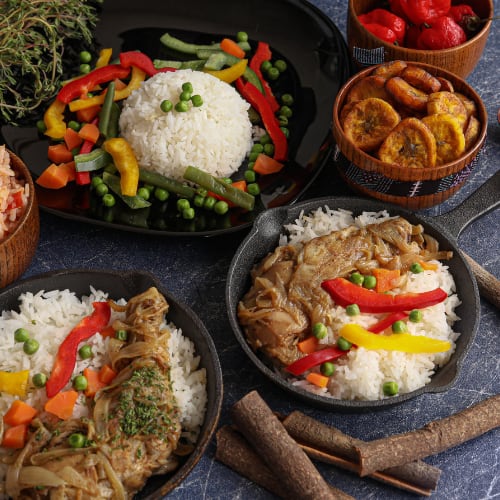 Assortment of Jamacian dishes using chicken, rice and vegetables