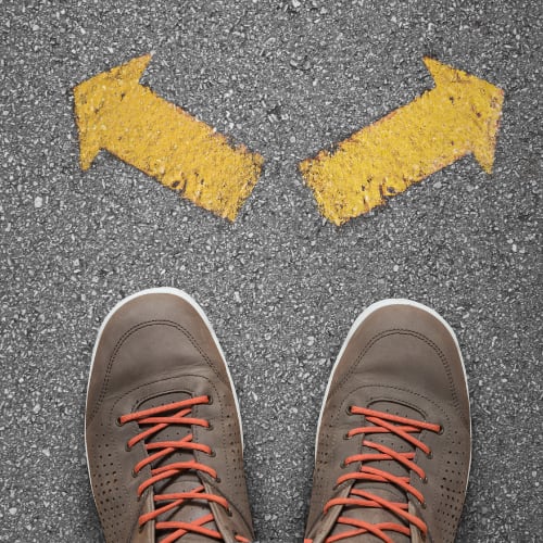 a pair of shoes on the ground with arrows in front of them indicating a choice to be made