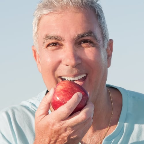 a man in his 50 enjoying a healthy apple