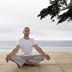 Middle-aged Man Meditating on Beach