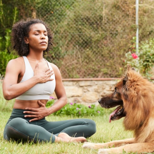 woman outside sitting practicing diaphragm breathing exercises demonstrating mindfulness