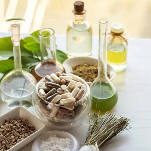 Various dietary supplements including capsules, powders, and softgels arranged on a neutral background.