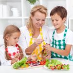 mother cooking healthy food with young son and daughter