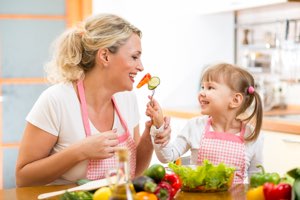 mother and daughter in kitchen enjoying a healthy salad together