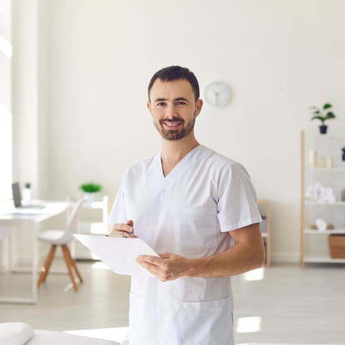 osteopathic healthcare provider in office holding clipboard