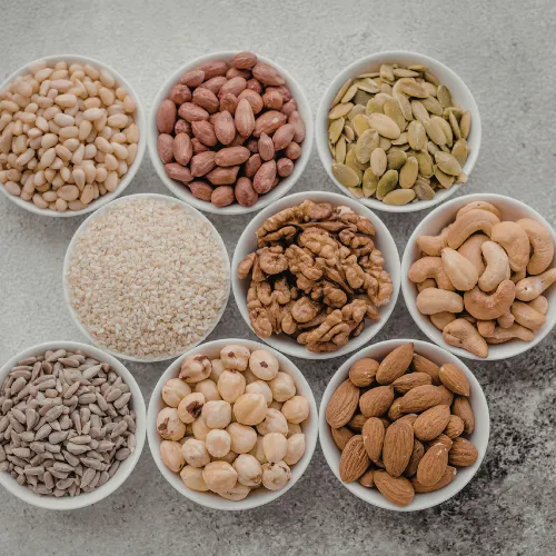 A selection of nuts, seeds, and plant-based oils arranged on a kitchen table.