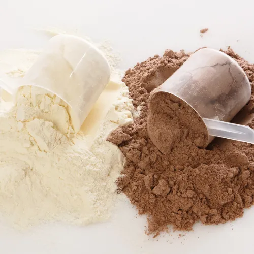 Plant-based and animal-based protein powders displayed side by side with smoothie ingredients and scoops of powder.