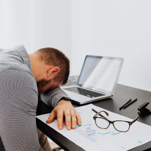 A tired person in the morning after a poor night of sleep, showing low energy and reduced focus.