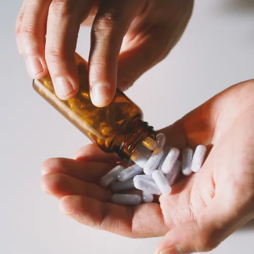 A combination of supplement capsules and fiber-rich foods arranged together to represent probiotics, prebiotics, and enzymes.
