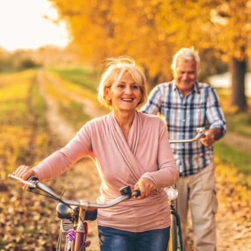 senior couple outdoors biking in Fall weather