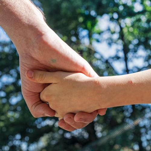 older woman and younger girl holding hands