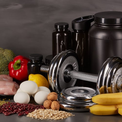 collection of healthy foods, water bottles, and supplements for sports nutrition health