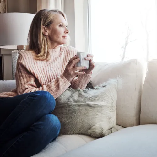 A person sitting calmly in a quiet environment, practicing stillness and relaxation to support nervous system balance and emotional steadiness.