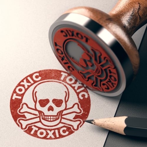 a hand stamp that imprints the word toxic with a skull and cross bones